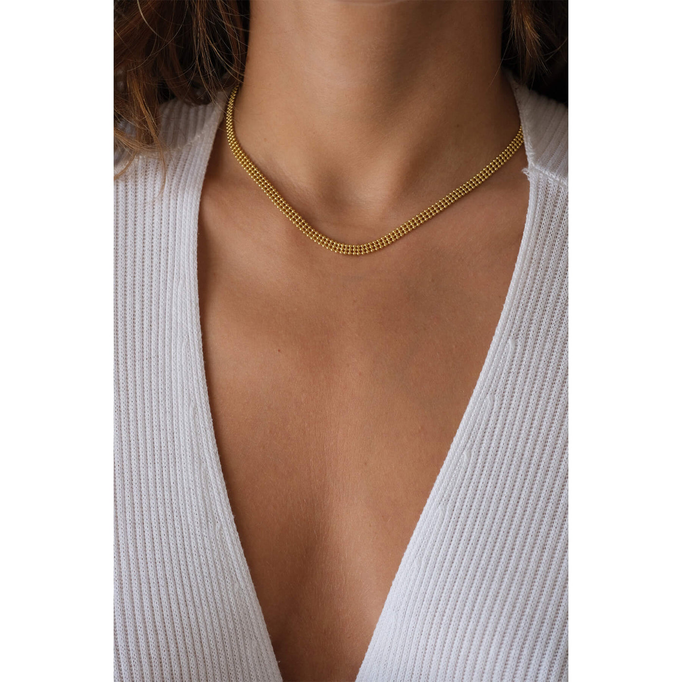 model wearing a lightweight chainlink necklace, handmade in Greece, 18K gold