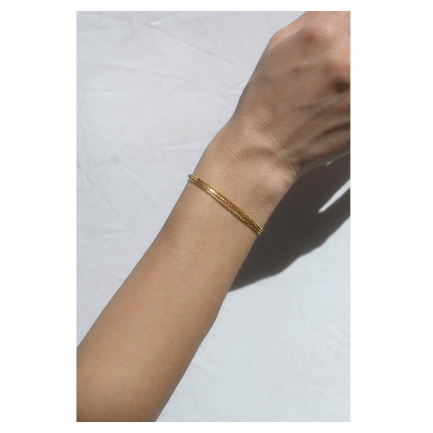 model wearing 18k gold chainlink bracelet, made in greece, handmade in greece