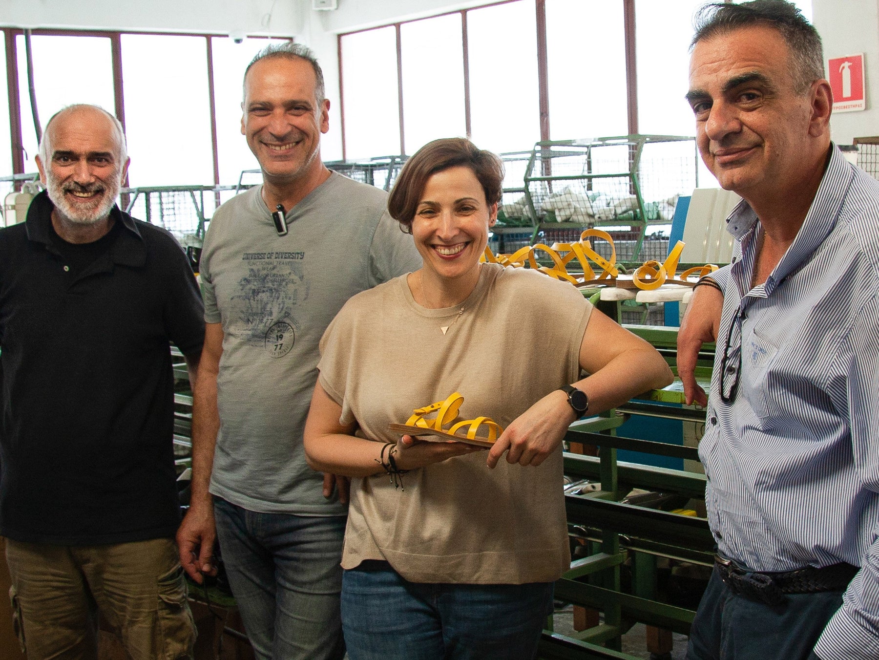 ares, dimitri, sofia and stefano at the greek factory in athens, holding a greek sandal, handmade