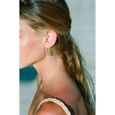 model wearing gold dangling earrings, handmade in Greece