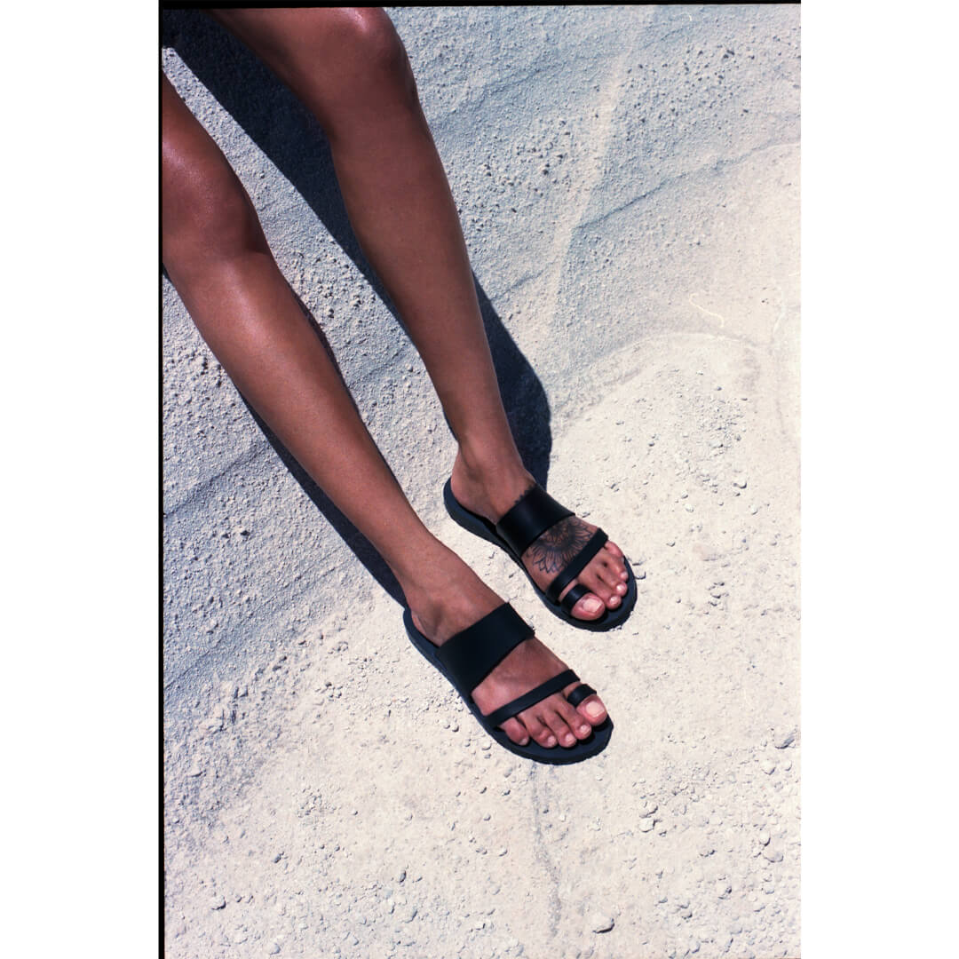 woman wearing black leather sandals, greek sandals, sandals made in greece #color_black